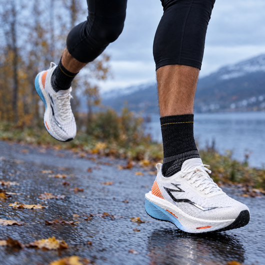 Runner wearing black merino running socks on a wet road