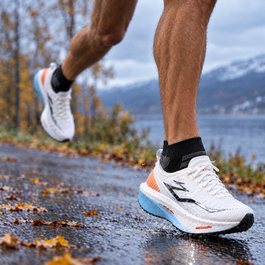 Runner wearing black ankle running socks on a wet road