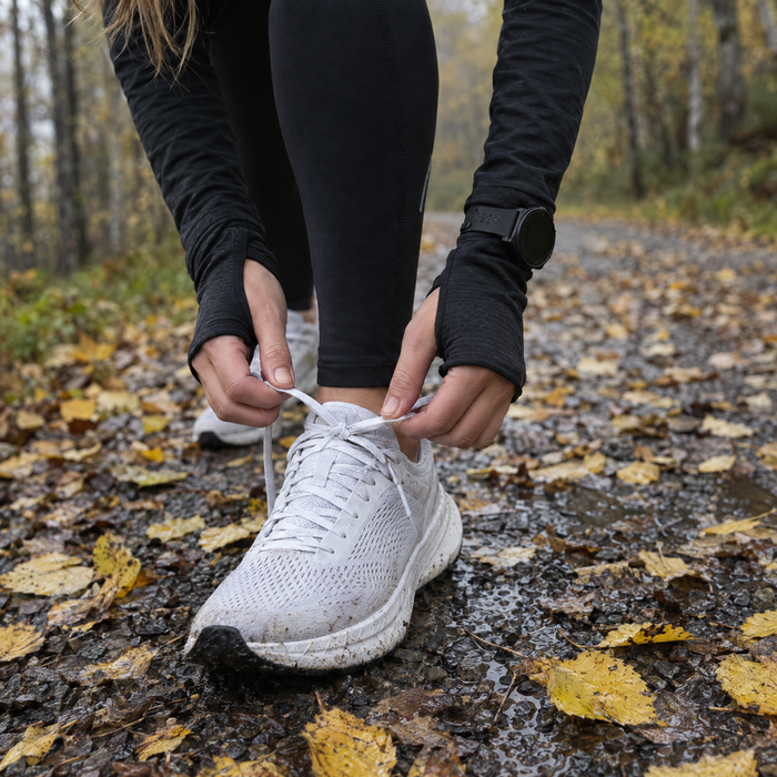 Tying running shoes on a forest path
